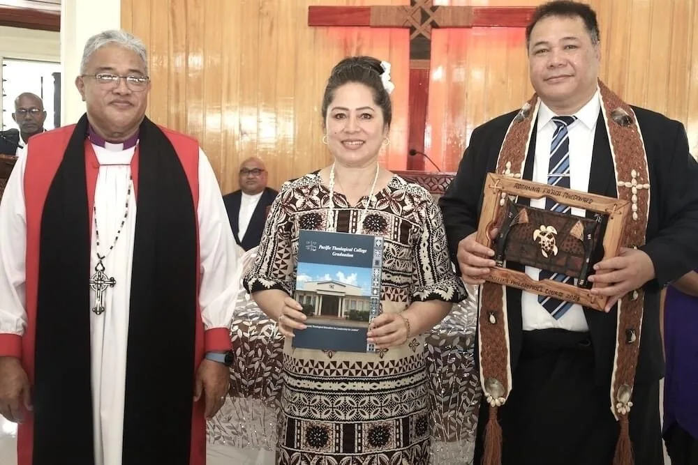 A woman stands between two men, smiling and holding a Pacifika College certificate. 